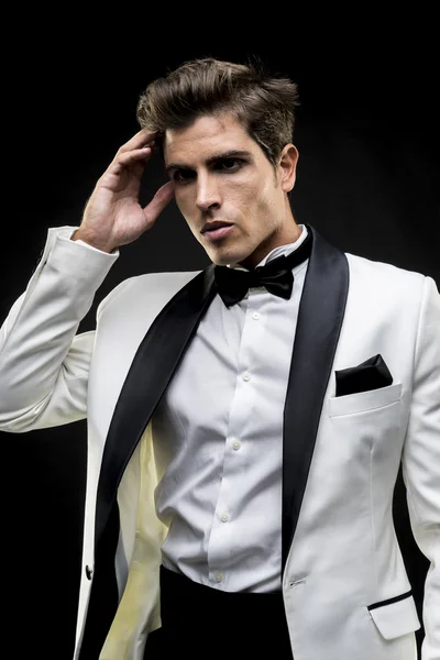 Luxury, elegant man in a white suit tuxedo with bow tie around h