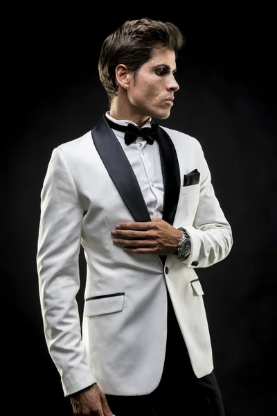 elegant man in a white suit tuxedo with bow tie around his neck