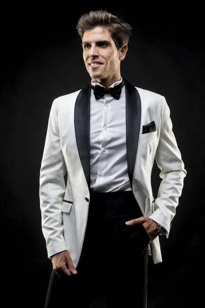 Elegant man in a white suit tuxedo with bow tie around his neck — Stock Photo, Image