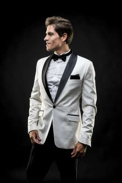 Elegant man in a white suit tuxedo with bow tie around his neck — Stock Photo, Image