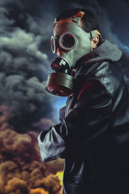 Silahlı adamın patlama arka plan üzerinde gaz maskesi