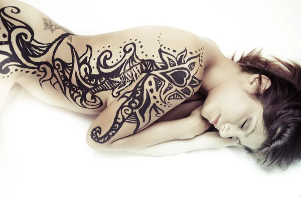 Young, naked woman with black bodyart — Stockfoto