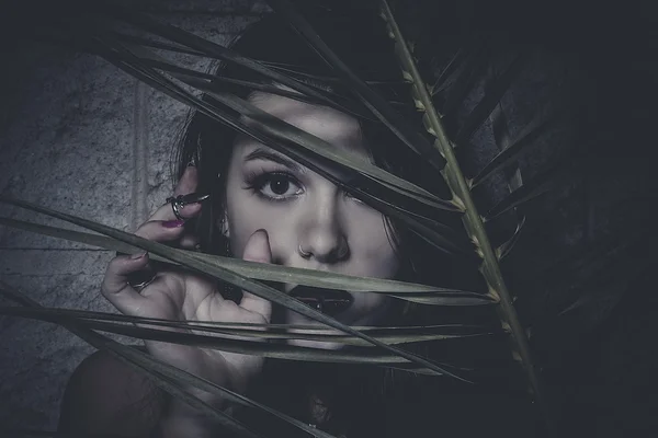 Femme regardant à travers les feuilles — Photo
