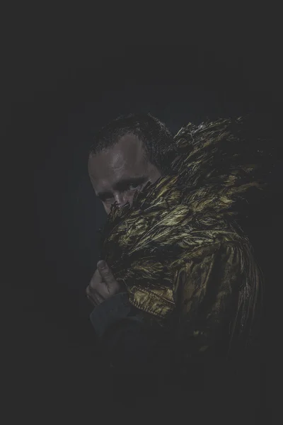 Человек с бородой и костюмом, сделанным из золотых крыльев — стоковое фото