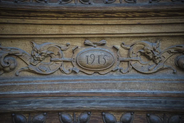 Oude houten deur met houtsnijwerk — Stockfoto