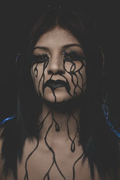 Woman with black bodyart on face — 图库照片