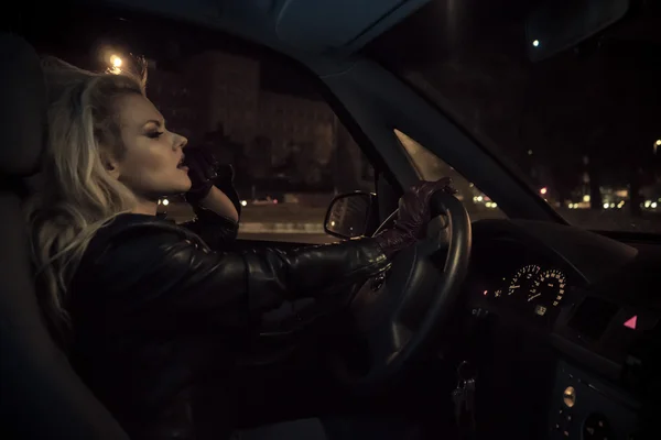 Blonde in car driving at night