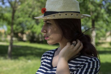 Young woman with straw hat in park