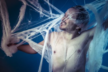 Naked man trapped in spider web