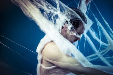 Naked man trapped in spider web
