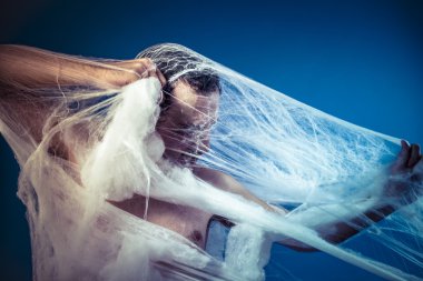 Naked man trapped in spider web