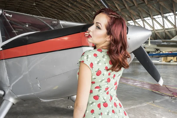 Femme en robe colorée près de vintage aircraf — Photo