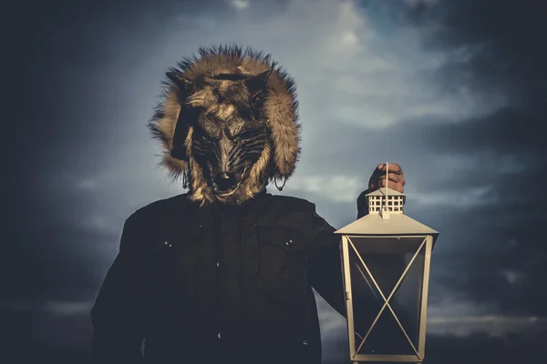 Hombre con máscara lobo y lámpara con humo de color — Foto de Stock