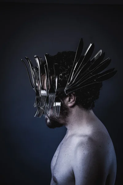 Man with a crown of forks and knives — Stock Photo, Image