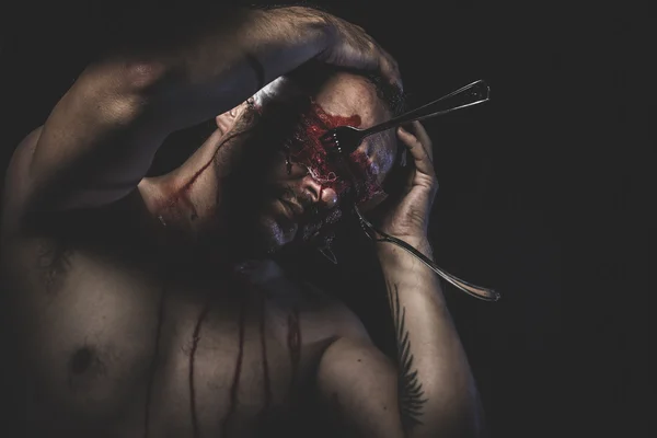 Man with bloody eyes fixed of forks — Stock Photo, Image