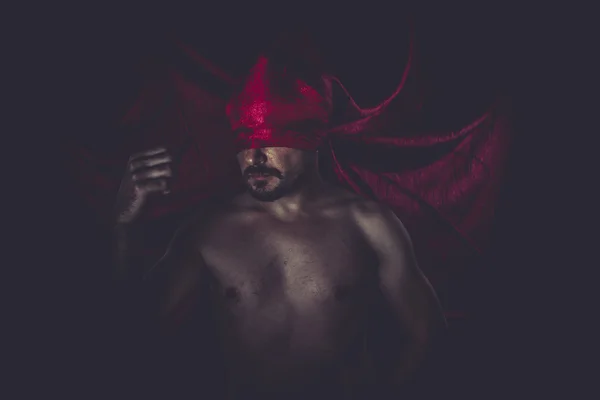 Mann auf rotem Tuch vor den Augen — Stockfoto