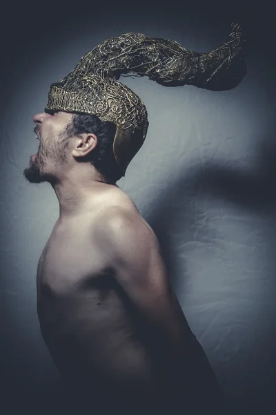 Hombre desnudo con casco guerrero trompetas — Foto de Stock
