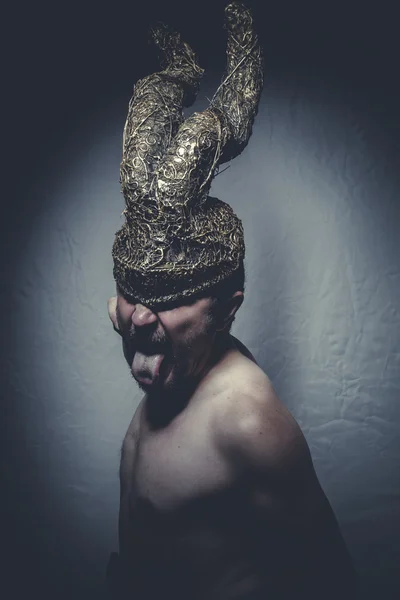 Uomo nudo con casco guerriero trombe — Foto Stock