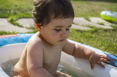 Çocuk suyla oynuyor.