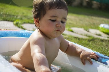 Çocuk suyla oynuyor.