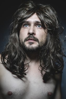 Kameraya bakarak büyük kahverengi saçlı çıplak adam