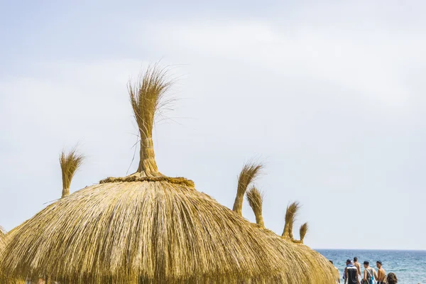 Stro paraplu's op de oever van de zee — Stockfoto