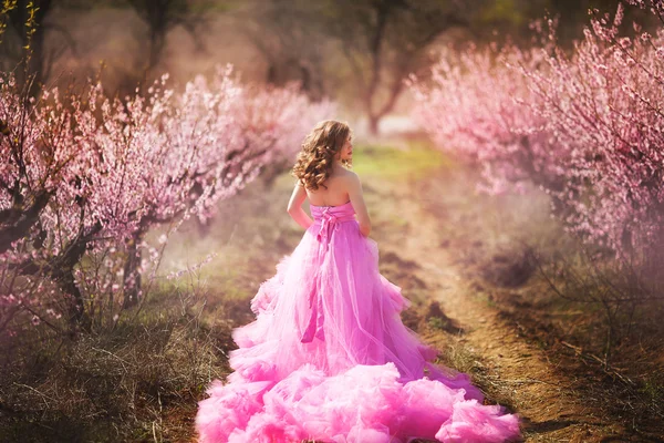 beautiful girl in a pink dress in peach garden