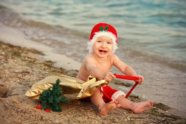Bebek Noel Baba kumlu bir plaj üzerinde — Stok fotoğraf
