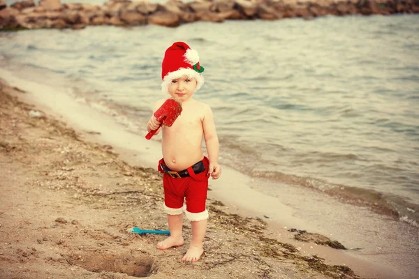 Bebek Noel Baba kumlu bir plaj üzerinde — Stok fotoğraf