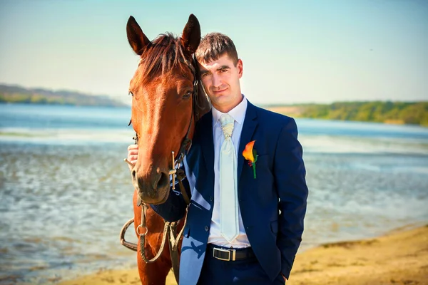 Novio con caballo marrón — Foto de Stock