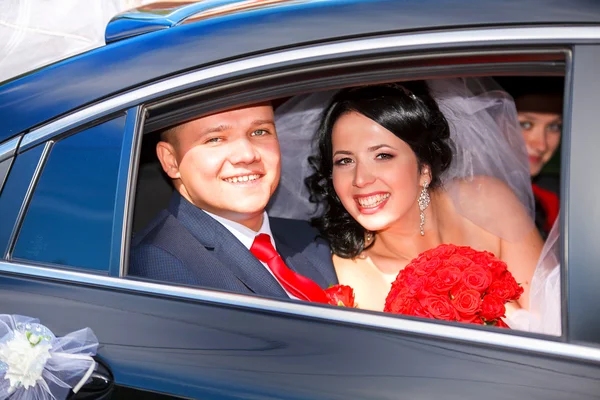 La novia y el novio se divierten al volante del coche retro. Boda. — Foto de Stock