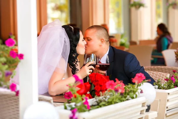 Bride and groom drinking coffee at an outdoor cafe — Stock Photo, Image