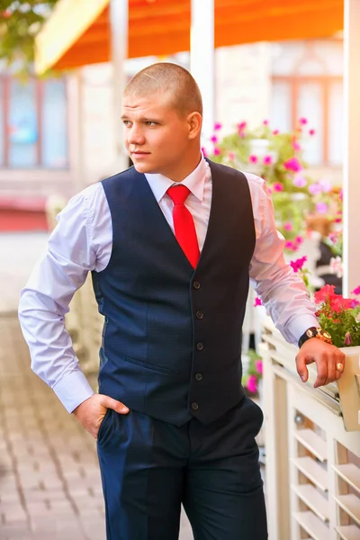 Bonito noivo no smoking de casamento sorrindo e esperando pela noiva . — Fotografia de Stock