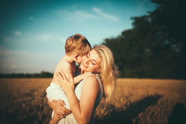 Mom and son having fun by the lake, field outdoors enjoying nature. Silhouettes on sunny sky. Warm filter and film effect — Stock Photo, Image