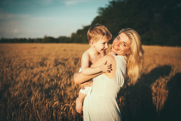 Mom and son having fun by the lake, field outdoors enjoying nature. Silhouettes on sunny sky. Warm filter and film effect — Stock Photo, Image