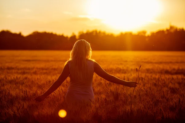 Schoonheid romantische meisje buitenshuis. Mooie tiener Model meisje in Casual korte jurk op het veld in zonlicht. Lange haren blazen. Herfst. Gloed zon, zon. Verlicht. Afgezwakt in warme kleuren — Stockfoto