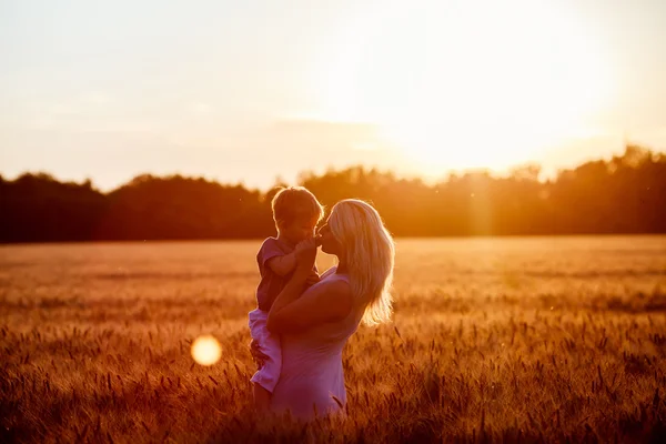 Mutter und Sohn amüsieren sich am See, das Feld im Freien genießt die Natur. Silhouetten am sonnigen Himmel. warmer Filter und Filmeffekt — Stockfoto