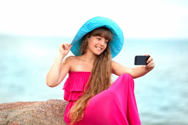 Flicka med självporträtt på stranden Stockbild