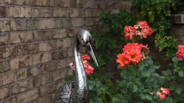 Metalen vogel standbeeld in een tuin. — Stockvideo