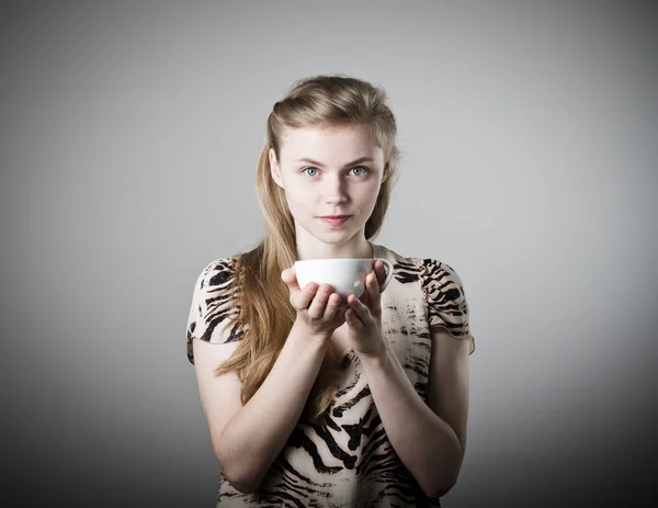 Jonge slanke vrouw houdt een mok. — Stockfoto