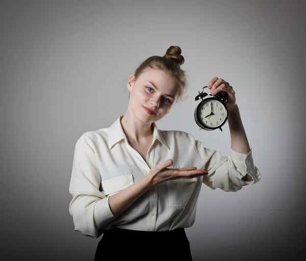 Girl pointing at a clock. — Stock Photo, Image
