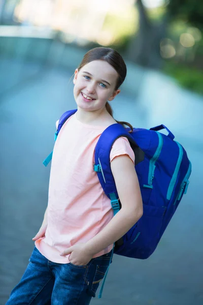 Brunette middelste schoolmeisje buiten met een paarse rugzak klaar — Stockfoto