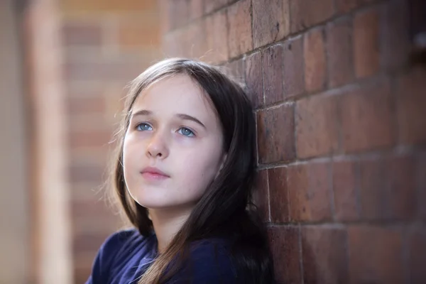 Una jovencita en un callejón mirando contemplativa y sola — Foto de Stock