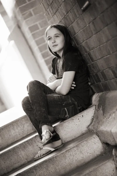 Une jeune fille dans une ruelle regardant contemplatif et seul Images De Stock Libres De Droits