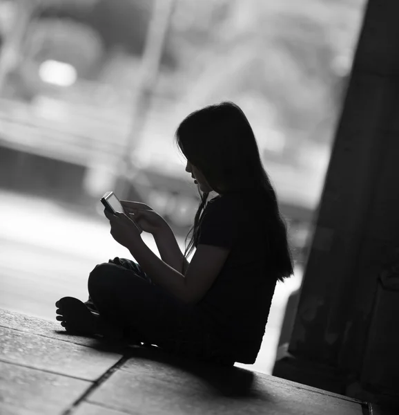 Silhouet van een jong meisje op haar tablet-pc Rechtenvrije Stockfoto's