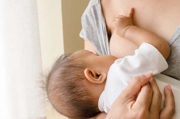 Anya szoptatás újszülött gyermekét mellett ablak — Stock Fotó