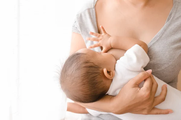 Borstvoeding moeder haar pasgeboren baby naast venster — Stockfoto