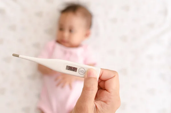 Dijital termometre ile Asya bebek sıcaklık ölçme