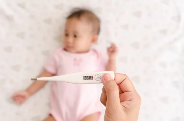 Pomiar temperatury Azjatki baby z termometr cyfrowy — Zdjęcie stockowe