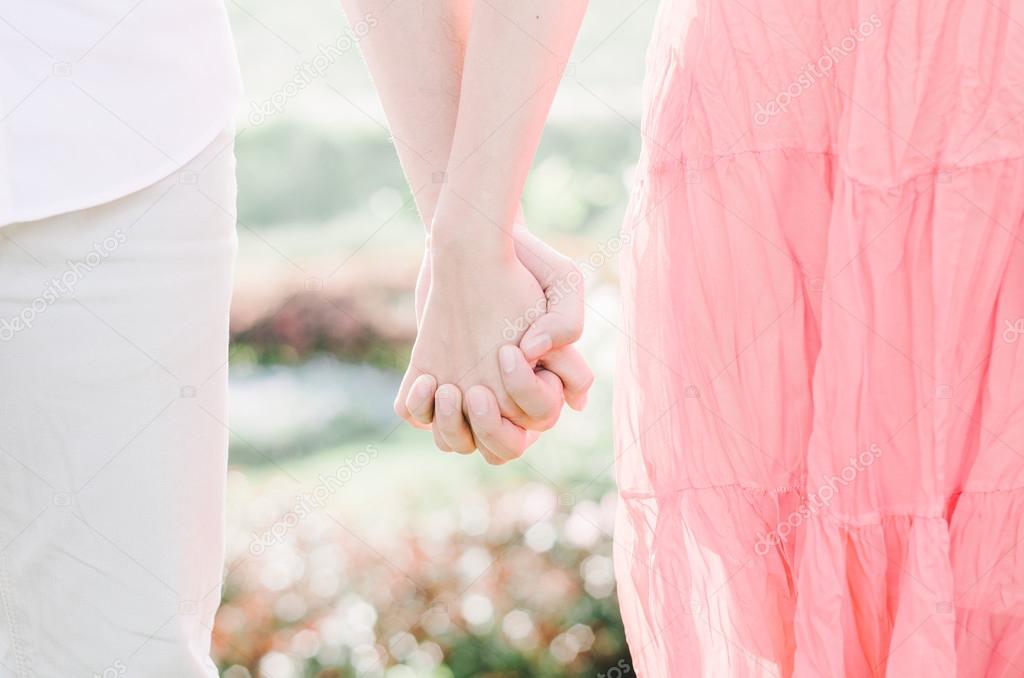 Young lovers couple holding hands